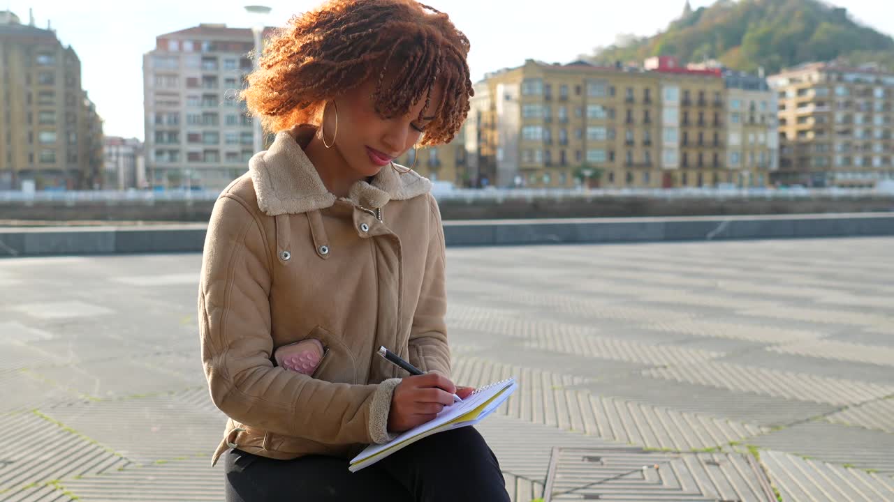 Young Woman Writing in Notebook Outdoors