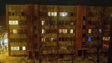 Hermosa-Vista-Nocturna-De-Lapso-De-Tiempo-Del-Antiguo-Edificio-De-Apartamentos-De-La-época-Soviética-En-La-Ciudad-De-Liepaja,-Luces-Que-Iluminan-Las-Ventanas,-Tiro-De-Gran-Angular