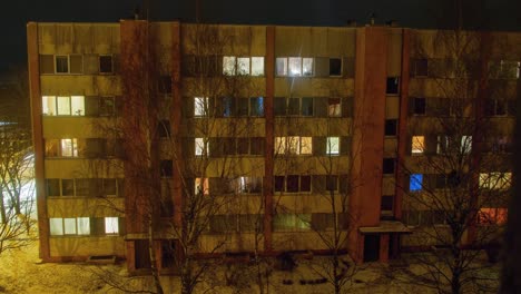 beautiful timelapse night view of old soviet time apartment building in liepaja city , lights illuminating windows, wide angle shot