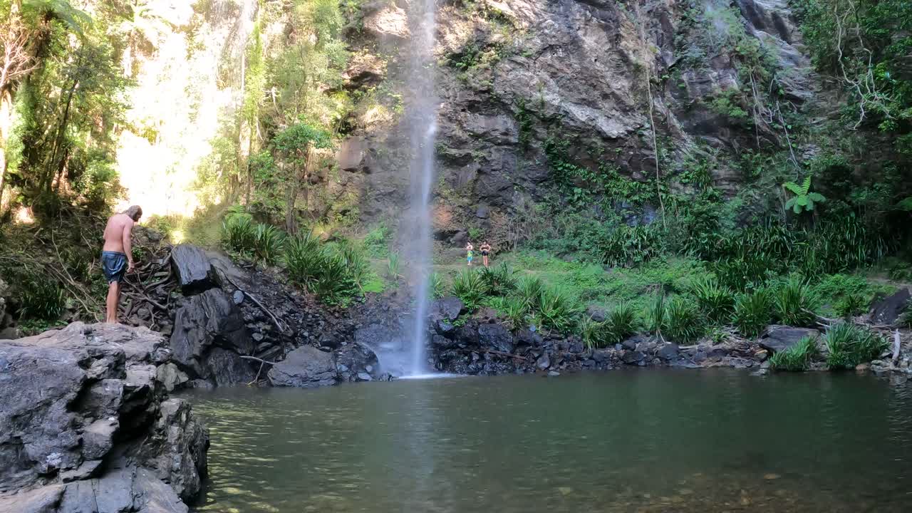 persona disfruta de una cascada serena en un entorno exuberante