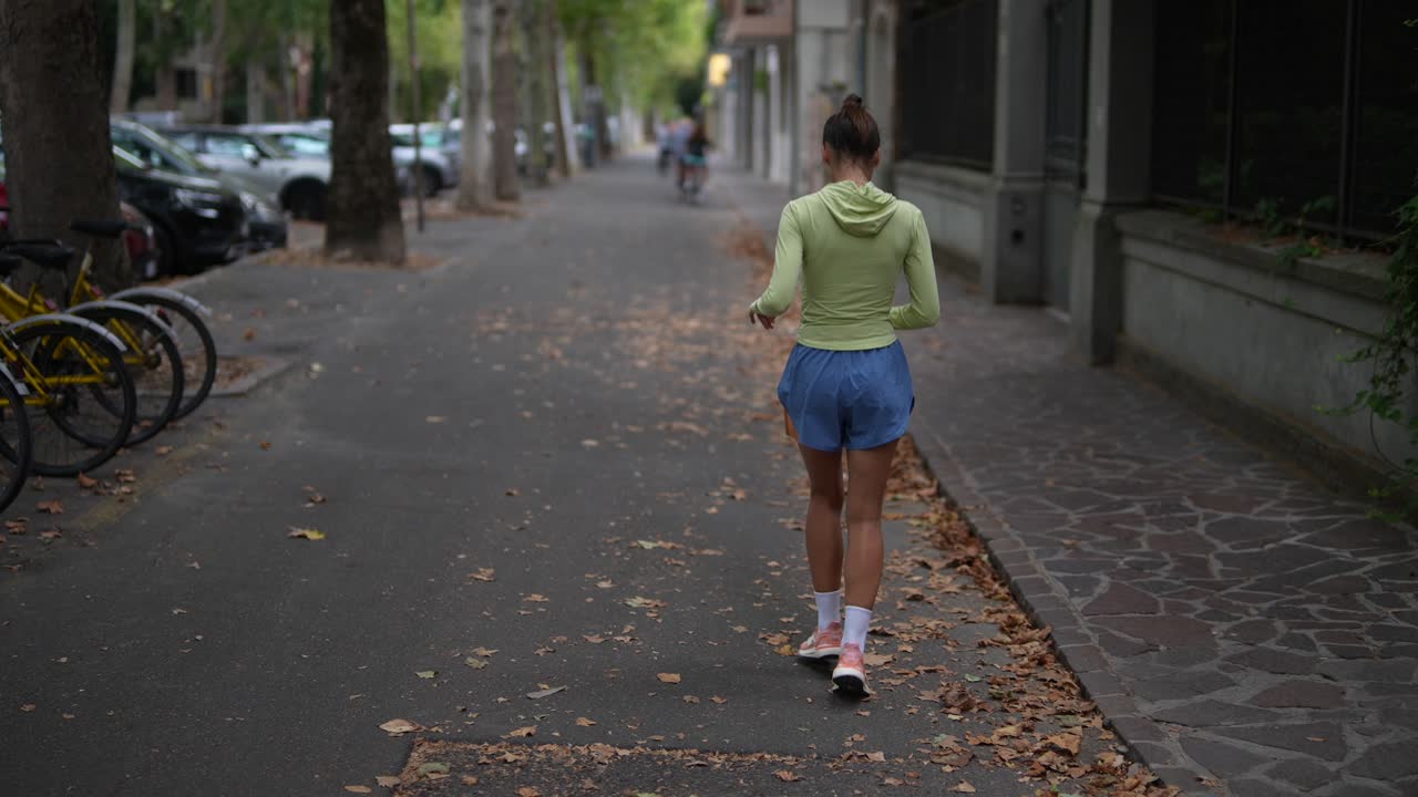 mujer caminando por una calle de la ciudad en otoño