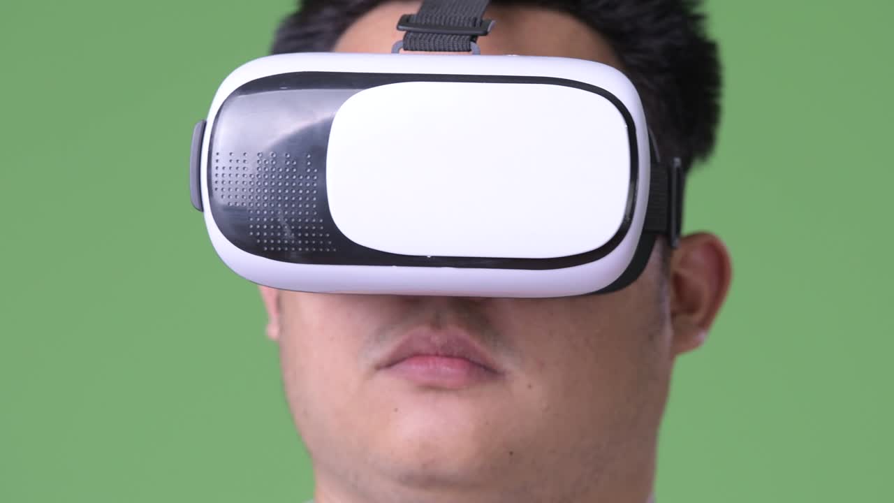 joven apuesto hombre asiático con sobrepeso contra un fondo verde