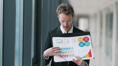 un joven elegante con gafas hace una presentación sobre infografías