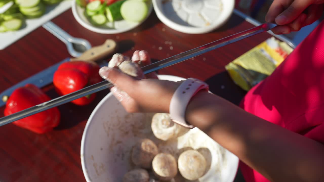 어린이가 야외에서 버섯 스피어를 준비하고 있습니다.