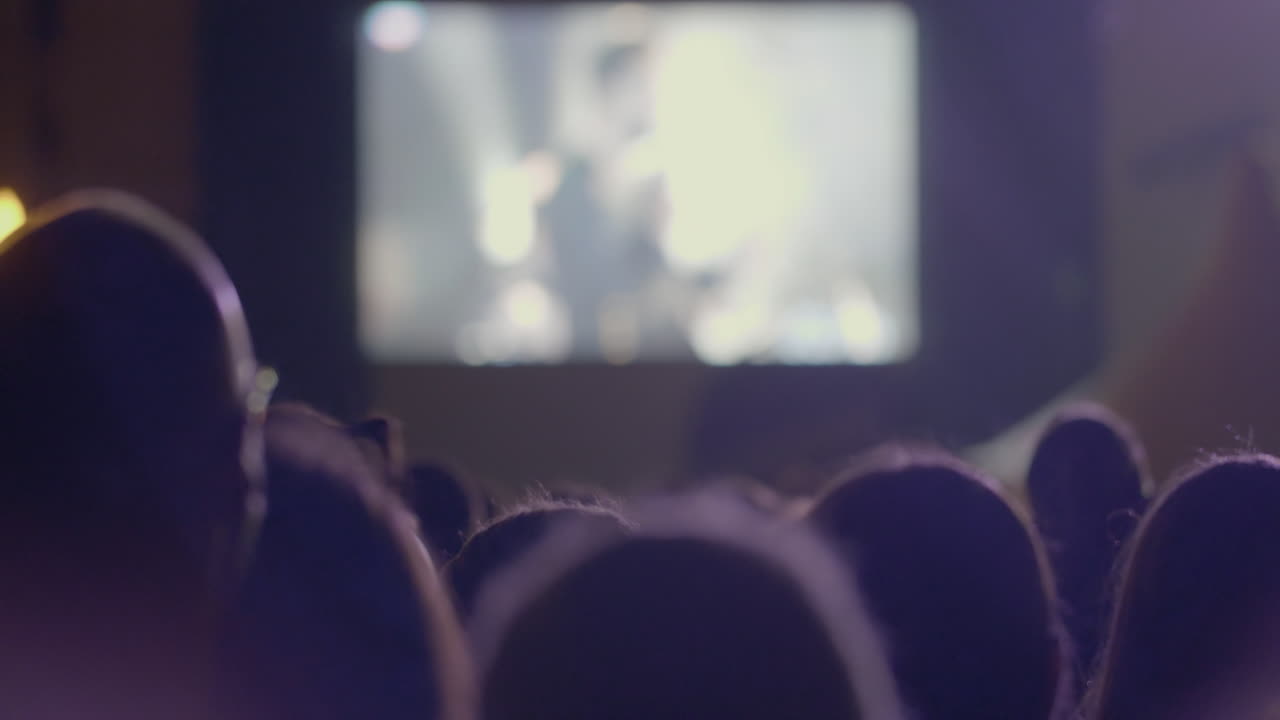 모스크바의 msu에서 콘서트에서 우리는 음악 그룹인 키노 (kino) 와 함께 있습니다. 많은 사람들이 그 장면을 보고 머리 위로 박수를 치고 있습니다.