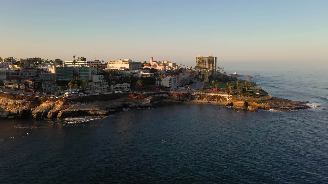 buceadores y buceadores explorando el agua del océano en la jolla cove en san diego, california - drone aéreo