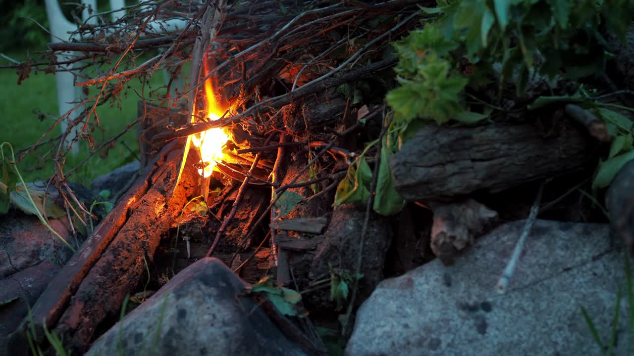 사람의 손은 불에 가지를 붙여서 불을 피운다.