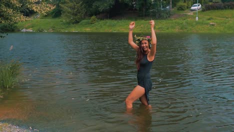 woman in nature, a pretty young happy girl, excited and enjoying the waters of pond during outdoor picnic hike