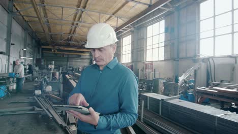 рабочий на заводе с помощью планшета