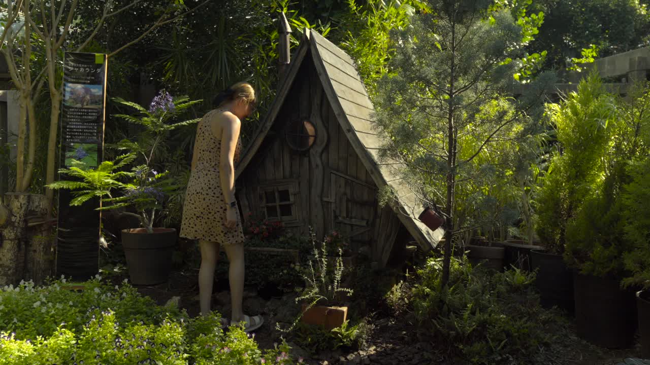 joven turista latina hermosa disfruta de la magia y el misterio de los jardines de la casa de madera verde en el centro de sueños tropicales prefectura de naha okinawa japón fantasía sonrisa secreta