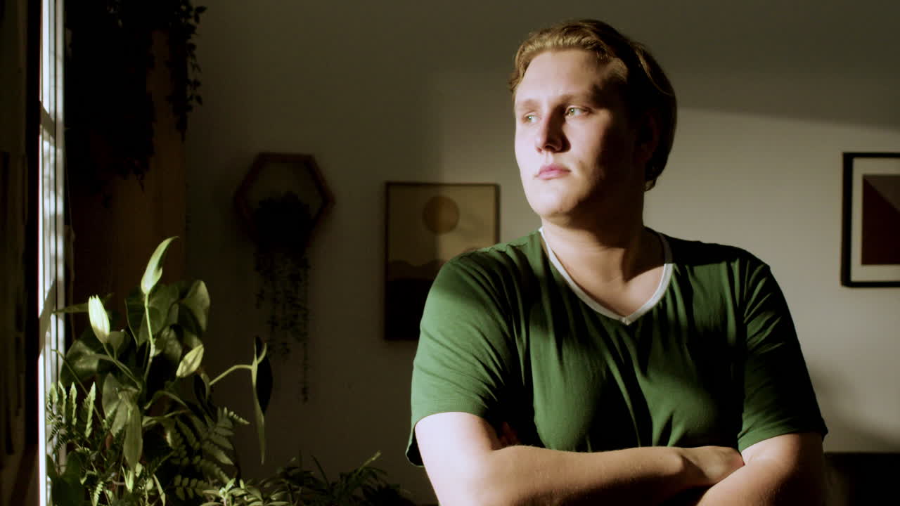 подросток смотрит в окно.