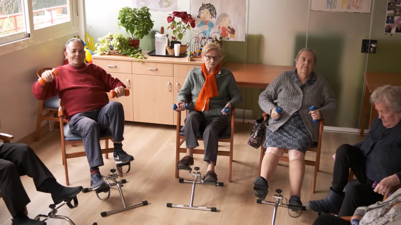 Senior people doing pedal exercises and lifting dumbbells at rehabilitation center