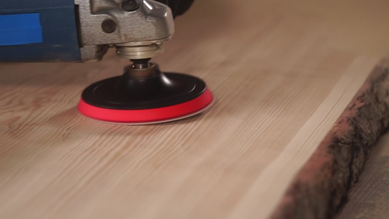 pulir una tabla de madera con una lijadora eléctrica