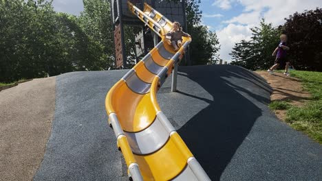 happy young girl having fun on an outdoor playground slide