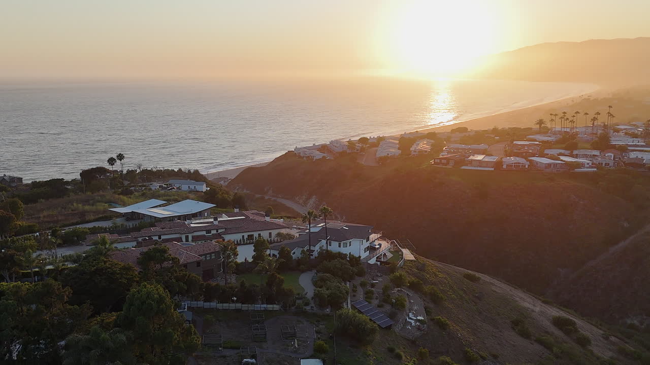 lente dorada flare océano puesta de sol aérea en la playa de malibu en california