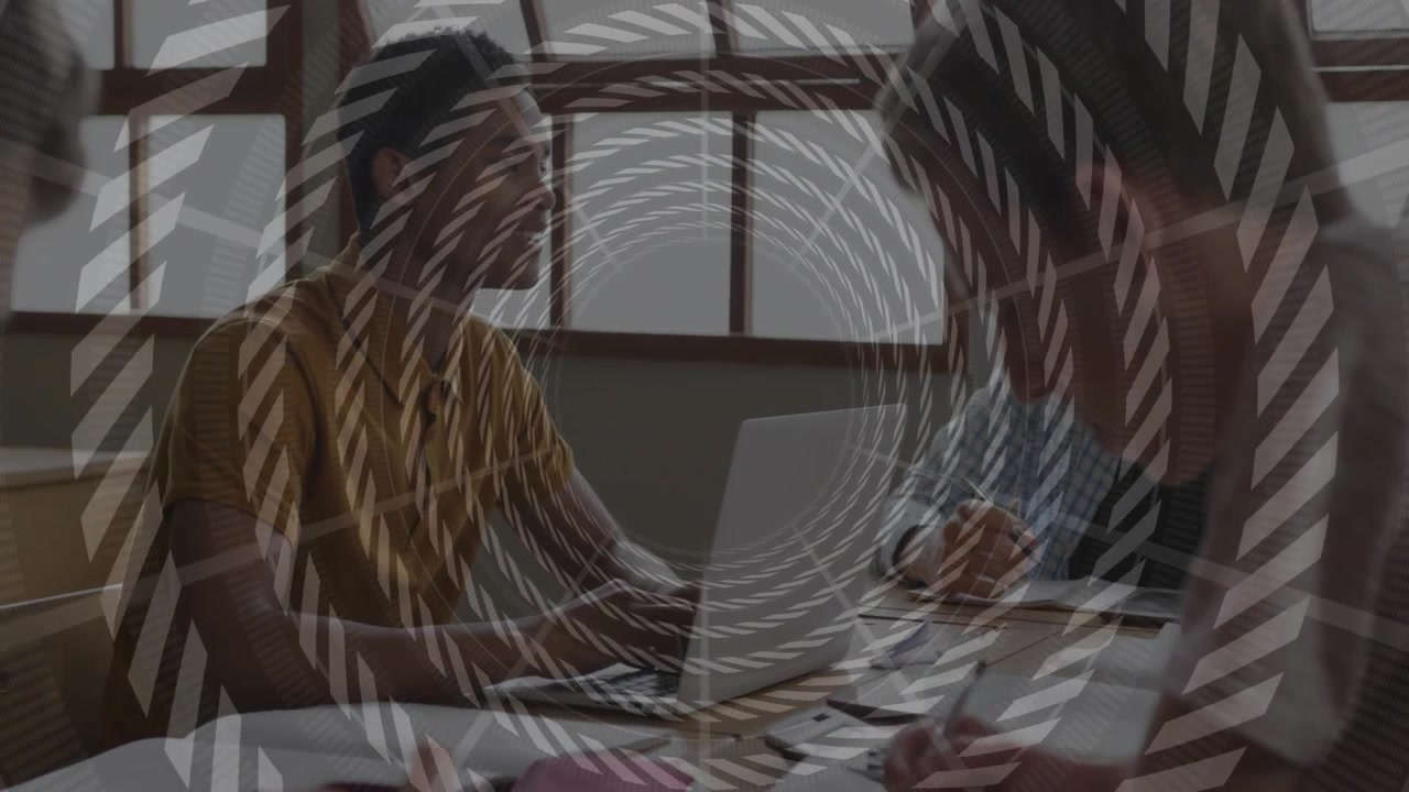Spiral overlay fading revealing business meeting, colleagues reviewing documents and using laptop