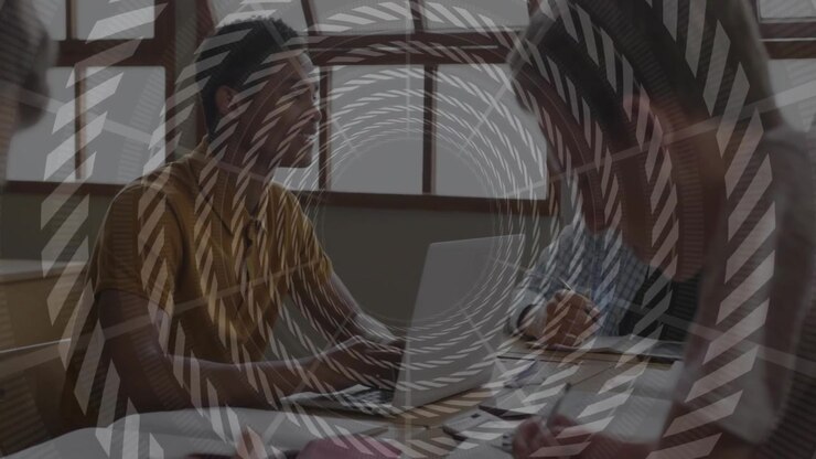 Spiral overlay fading revealing business meeting, colleagues reviewing documents and using laptop