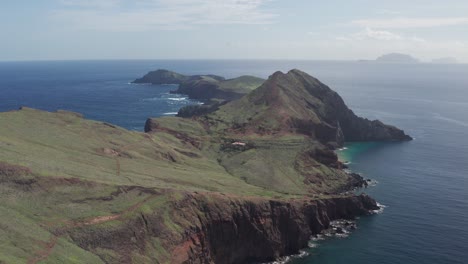 Epic-aerial-view-of-green-mountains-in-with-vast-blue-and-turquoise-ocean