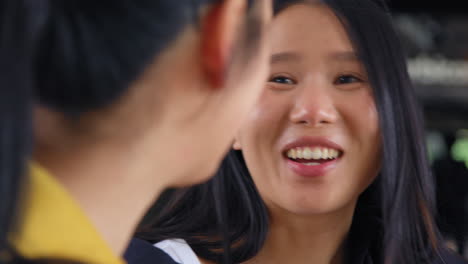 Close-Up-Of-Two-Smiling-Young-Female-Friends-Outside-Meeting-And-Talking-In-Urban-Setting-1