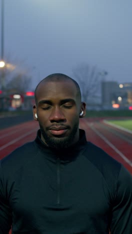 man running on track at dusk