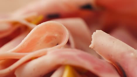 ham italian mordatella, man slices of traditional italian antipasti mortadella sausage on a wooden cutting board, close up macro of chicken or turkey jamon, fat breakfast dish.