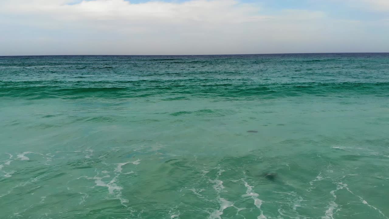 드론은 오스트레일리아 해안의 바위와 파도 위에서 낮게  ⁇ 습니다.