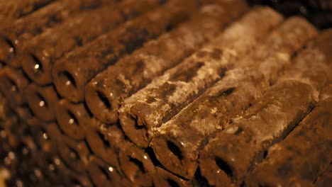 stacked wine bottles aging in a winery cellar