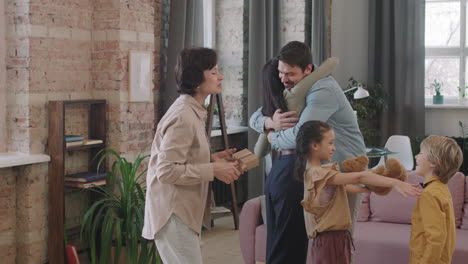 family celebrating birthday with gifts and hugs