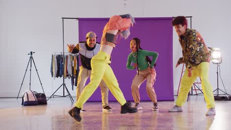 portrait of happy diverse male and female dancers dancing in dance studio, slow motion