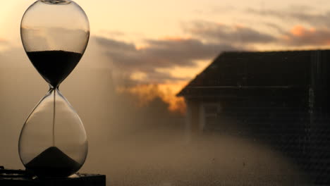 hourglass sand falling in sunset