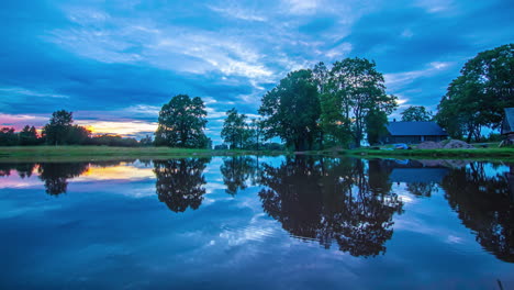 Magical-time-lapse-of-a-house-in-the-forest-being-reflected-in-the-still-lake-like-a-clear-mirror