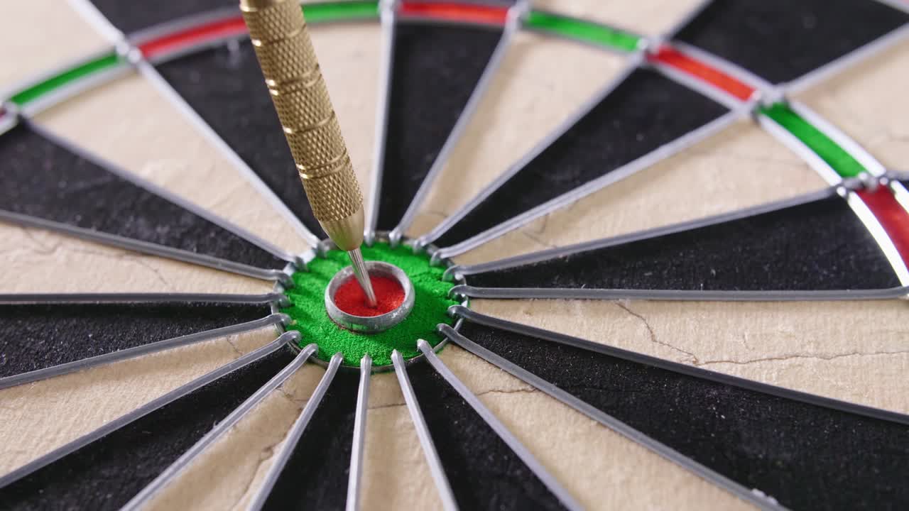 disparo de bloqueo de primer plano de un dardo golpeando el objetivo en el tablero de dardos