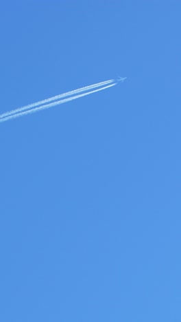 airplane in the blue sky with contrails