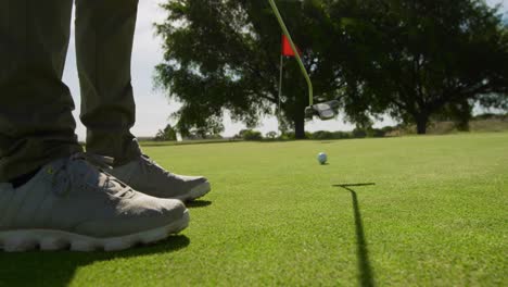jugador de golf golpeando la pelota con su club