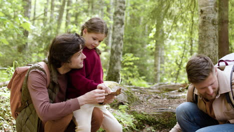 family gathering logs and dry leaves for fire camp