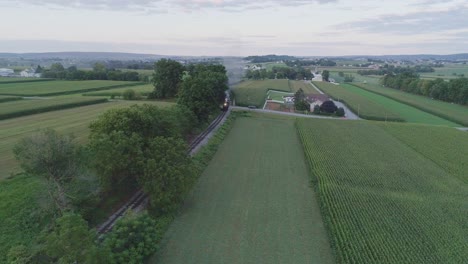 aerial view on an approaching steam passenger train in the amish countryside on a summer day