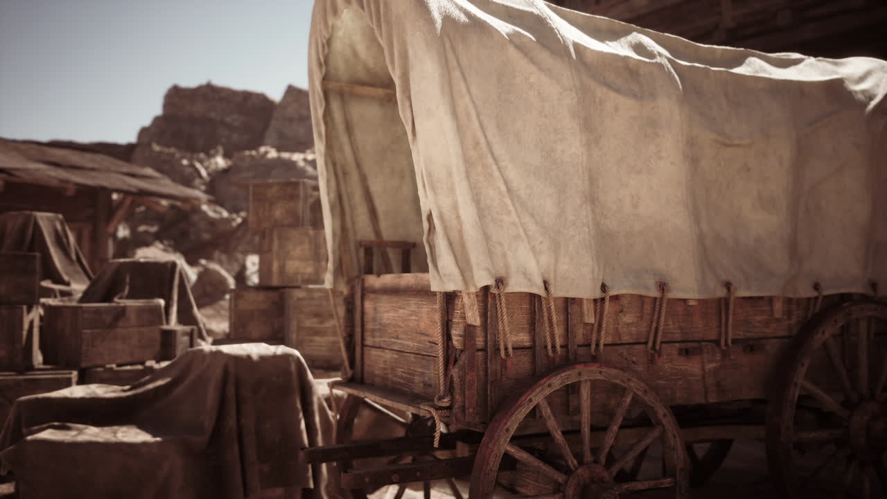 Rustic wooden wagon covered with a canvas tarp in a dusty old western town