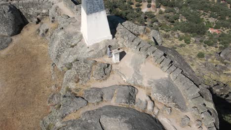 Woman-greets-drone-from-megalithic-fortification-of-Monsanto-Castle,-Portugal