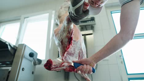 Butcher-Carving-Up-Lamb-Hanging-From-Hook