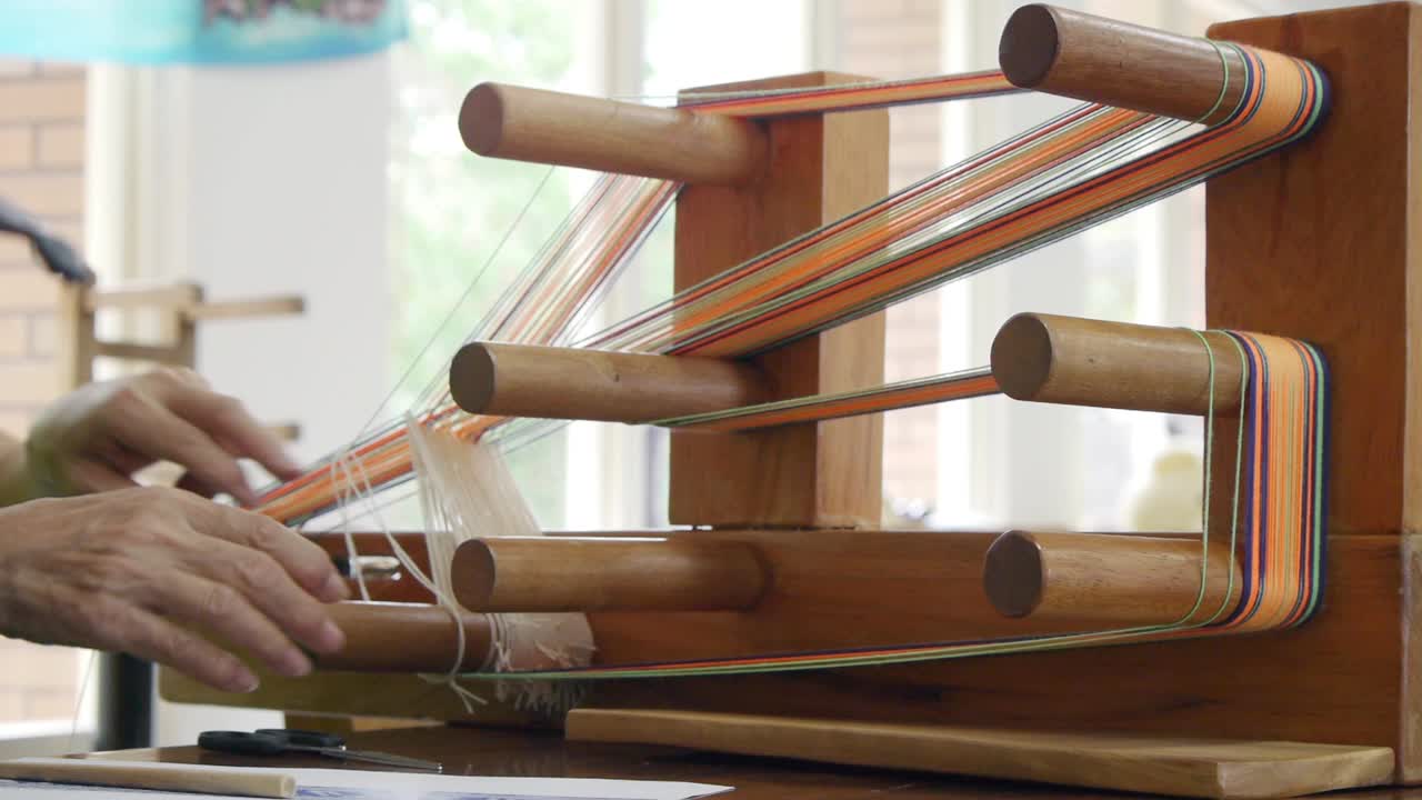 Yarn being looped onto traditional Asian wooden loom