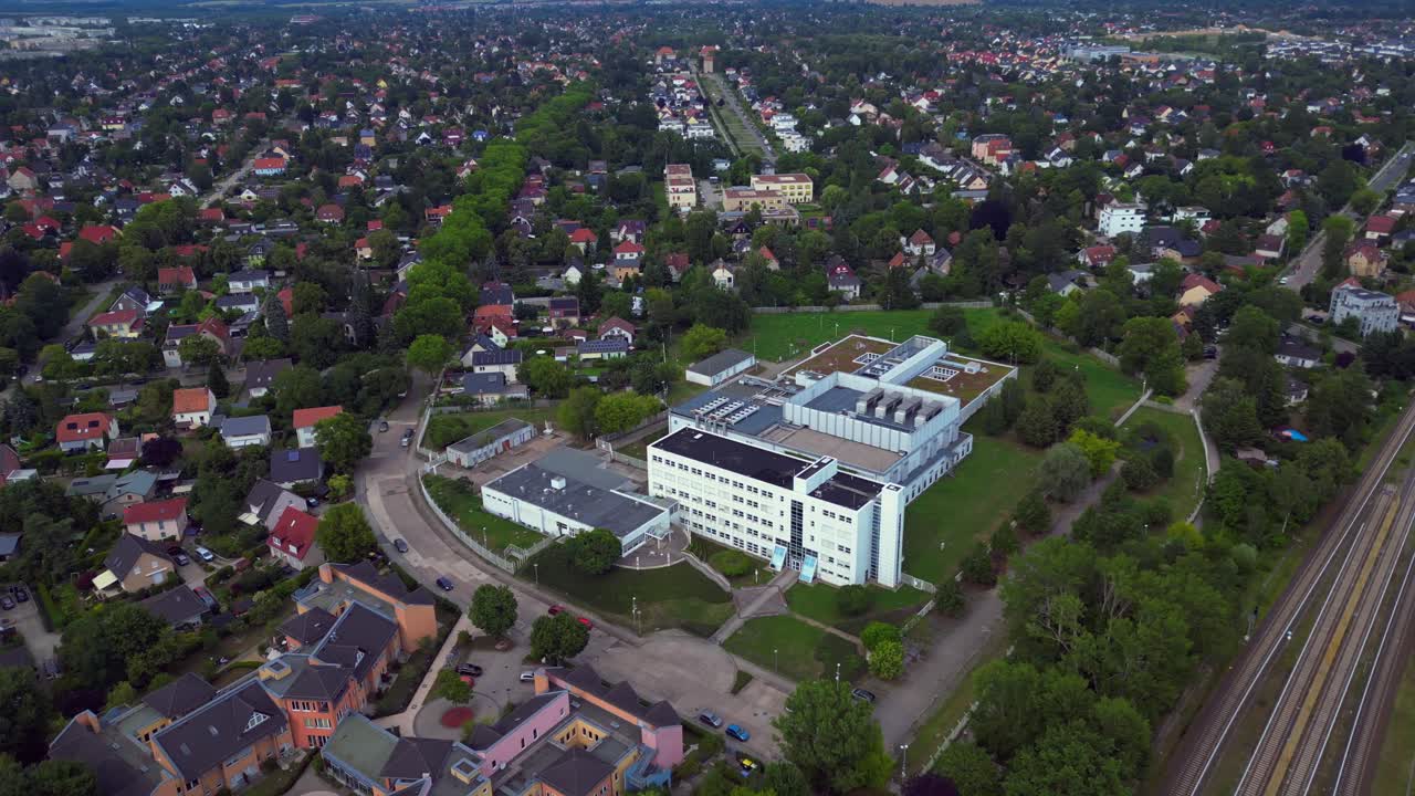 datacenter building with cooling system on the roof, surrounded by residential houses, showcasing urban and industrial integration. Lovely aerial view flight wide orbit overview drone
