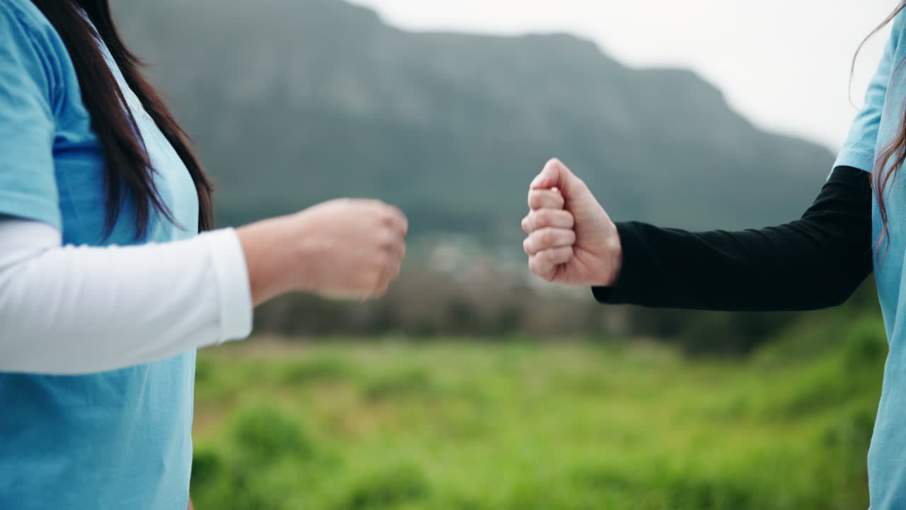 Volunteers fist bumping in front of a mountain