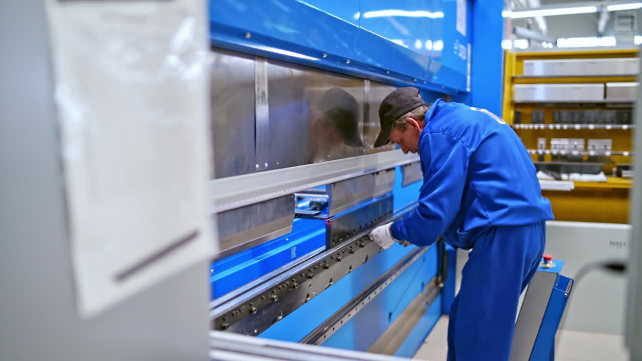 Worker at industrial factory checks the equipment. Technic and equipment at metal production factory. Closeup video.