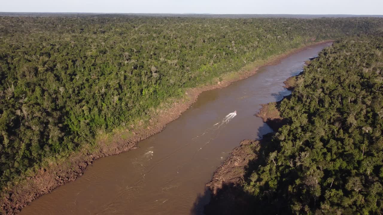 Motorboat along Iguazu River crossing Amazon rainforest at border between Brazil and Argentina