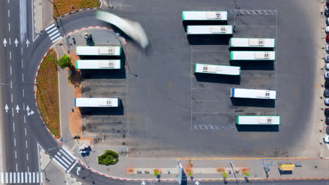 aerial time lapse of a central bus station in israel after leaving the complex, the buses stop at stations further down the road - drone top down hyperlapse