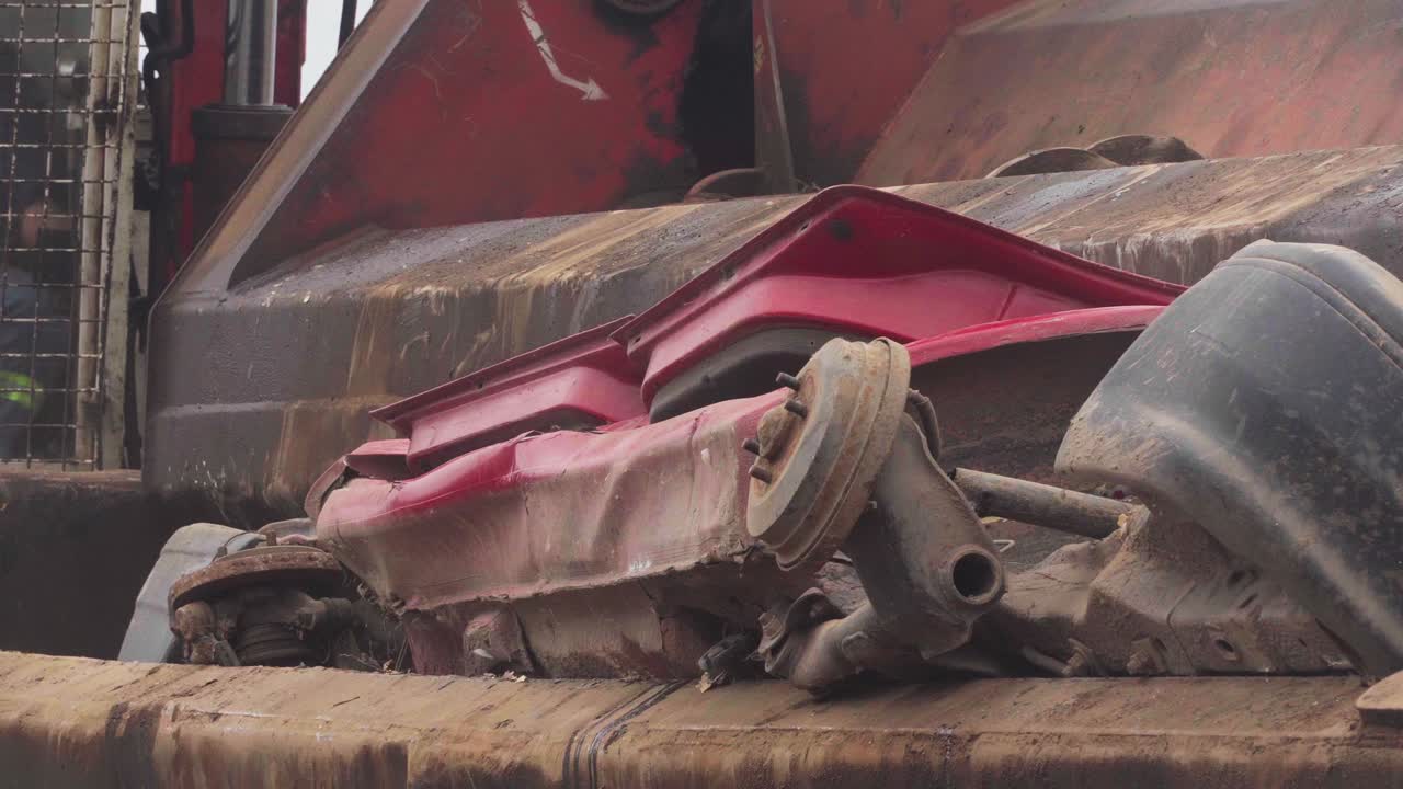 쓰레기장에서 자동차 분쇄기에 의해 분쇄되는 자동차