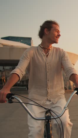 man riding a bicycle in the city at sunset