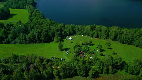Luftaufnahme-Von-Häusern,-Umgeben-Von-Grünen-Wäldern-Und-Einem-Weitläufigen-See