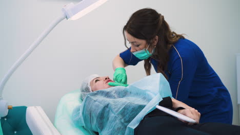 la esteticista hace una inyección para el aumento en el labio de la mujer