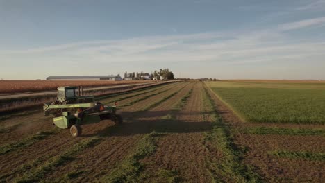 fall hay cutting in iowa with a john deere . drone following tractor in field.